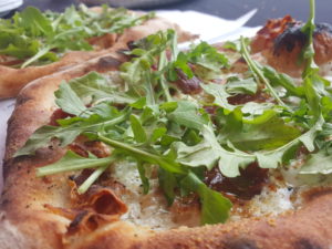 Cheese pizza with a lot of basil toppings